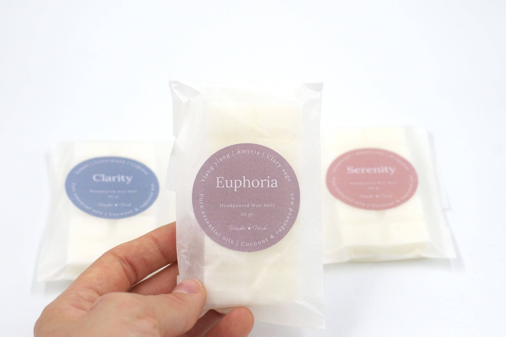 Close-up of Euphoria essential oil wax melt in eco-friendly packaging, highlighting ylang ylang, clary sage, and amyris scent for a romantic, floral ambiance.