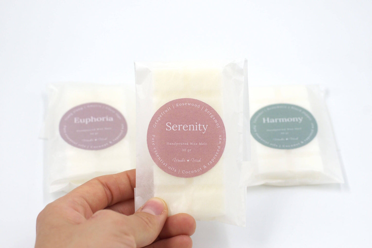 Close-up of Serenity essential oil wax melt in eco-friendly packaging, highlighting grapefruit, rosewood, and bergamot scent for a sweet, uplifting atmosphere.