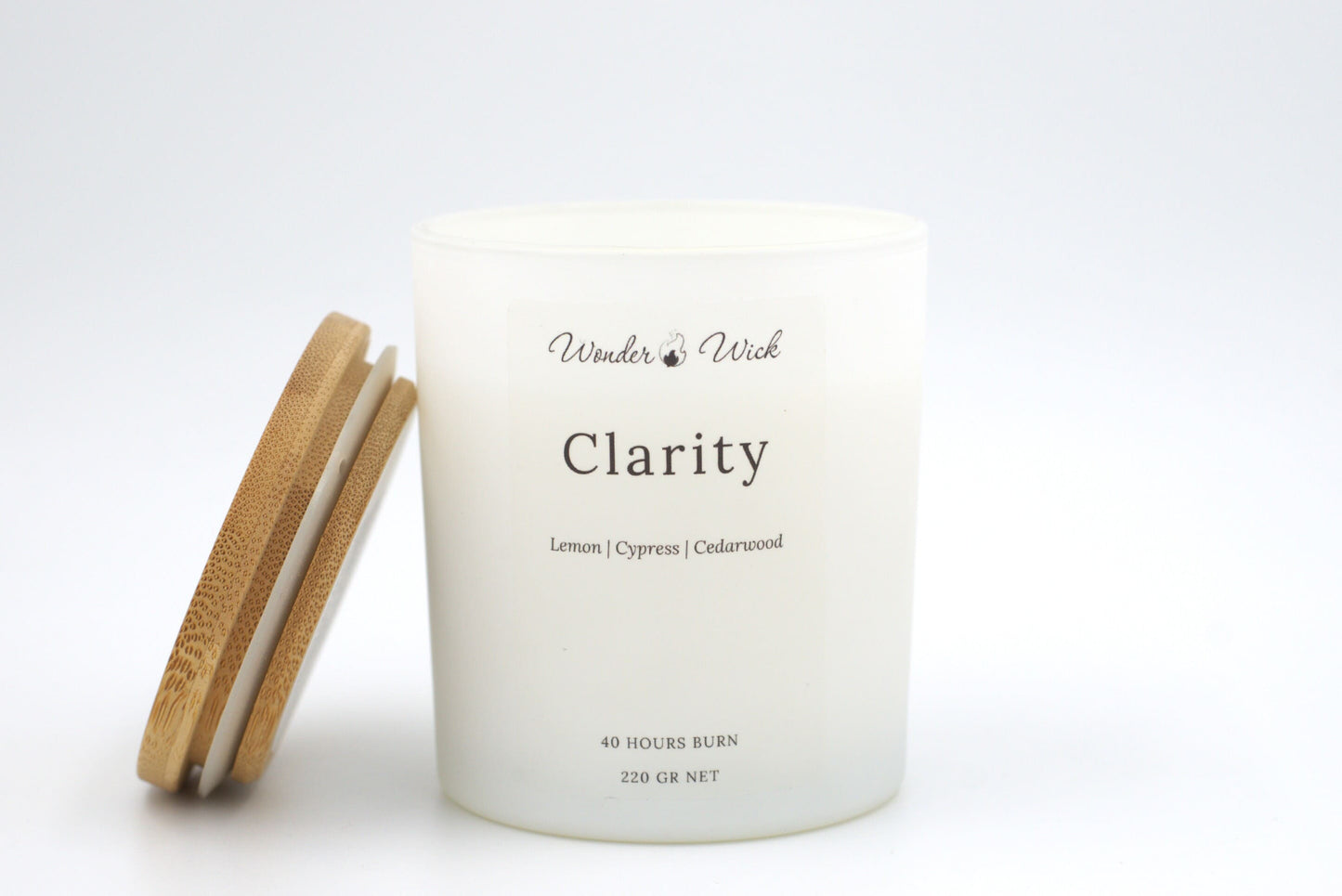 Clarity 40-hour burn candle with bamboo lid beside it, highlighting its elegant design and invigorating scent profile of lemon, cypress, and cedarwood.