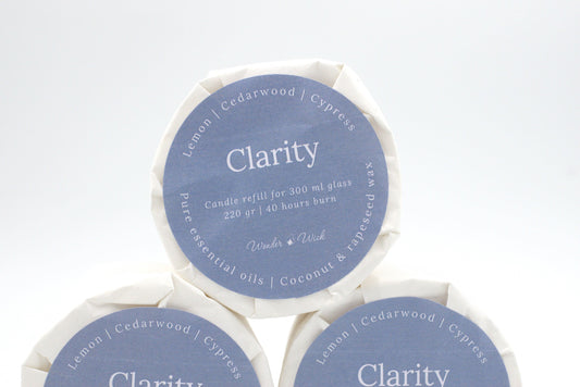 Clarity candle refill for 300 ml glass with 40 hours burn time, wrapped in eco-friendly packaging with a label showing lemon, cypress, and cedarwood essential oils.