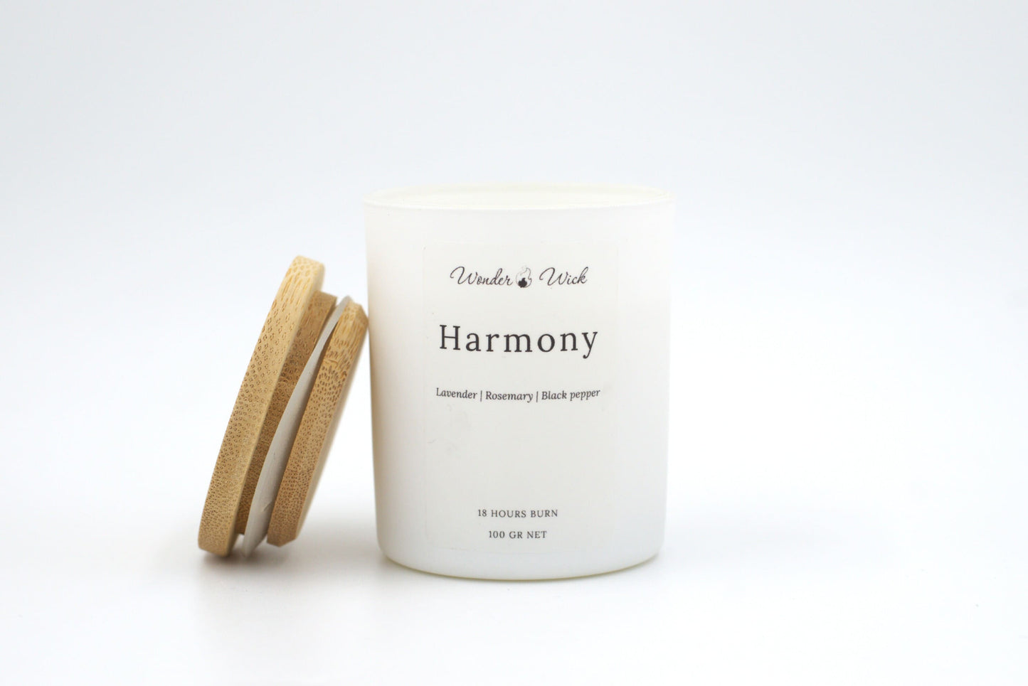 A 100-gram, 18-hour burn Harmony relaxing candle in a white matte glass jar with a bamboo lid. The soothing blend of lavender, rosemary, and black pepper promotes relaxation and stress relief.