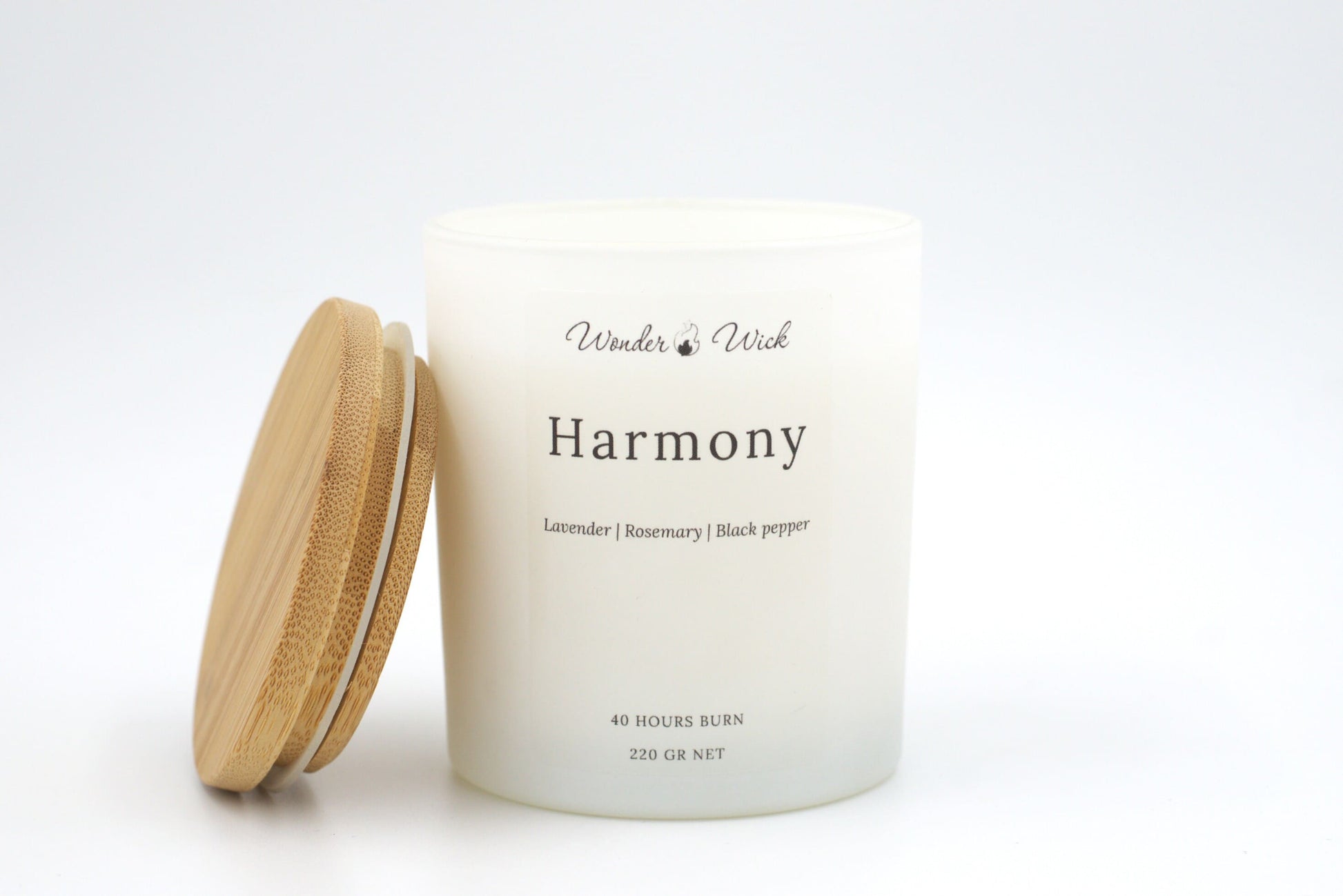 A 220-gram, 40-hour burn Harmony relaxing candle displayed with its bamboo lid beside it. This calming candle combines lavender, rosemary, and black pepper for a relaxing ambiance.