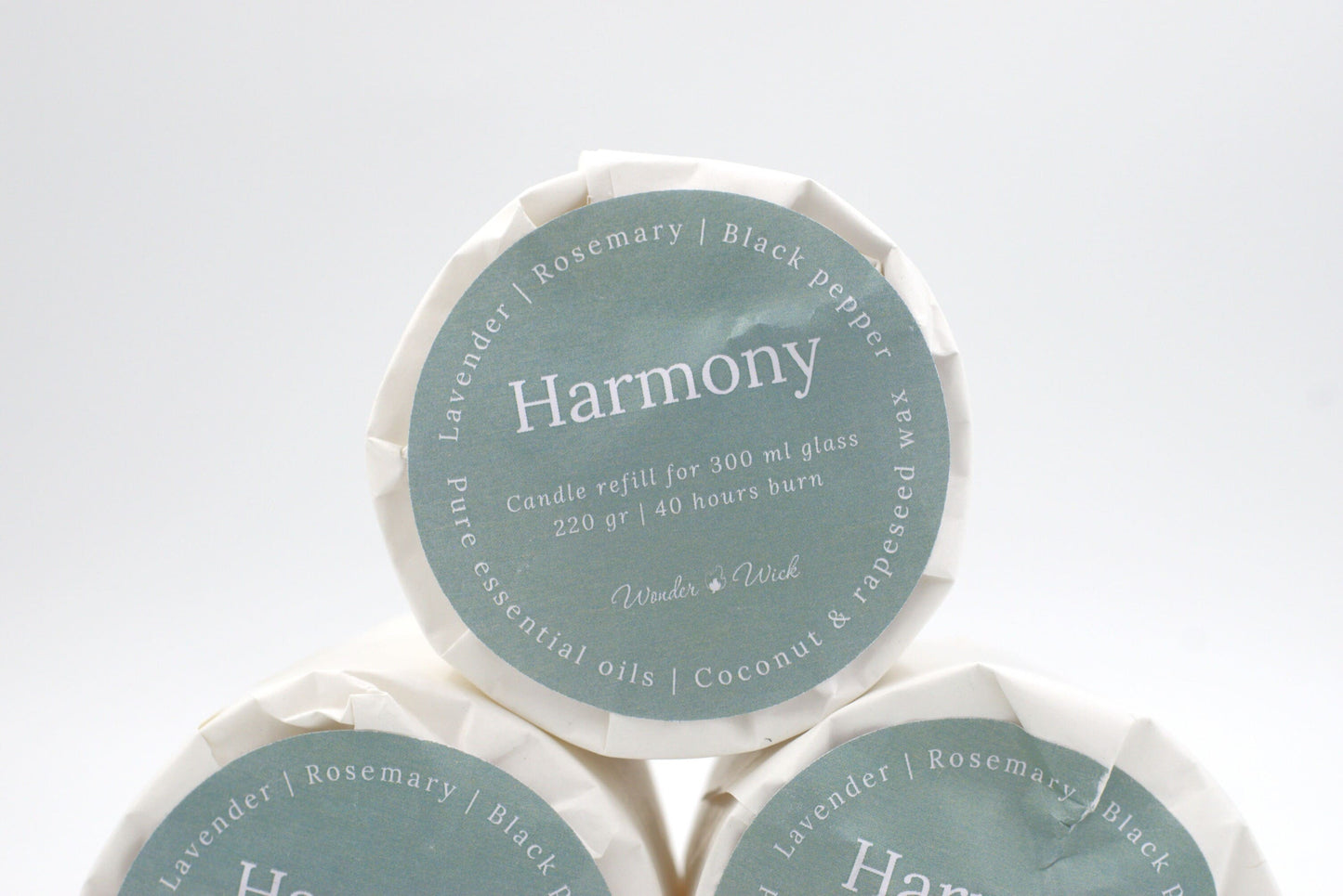 Harmony candle refill for 300 ml glass with 40 hours burn time, wrapped in eco-friendly packaging with a label showing lavender, rosemary, and black pepper essential oils.