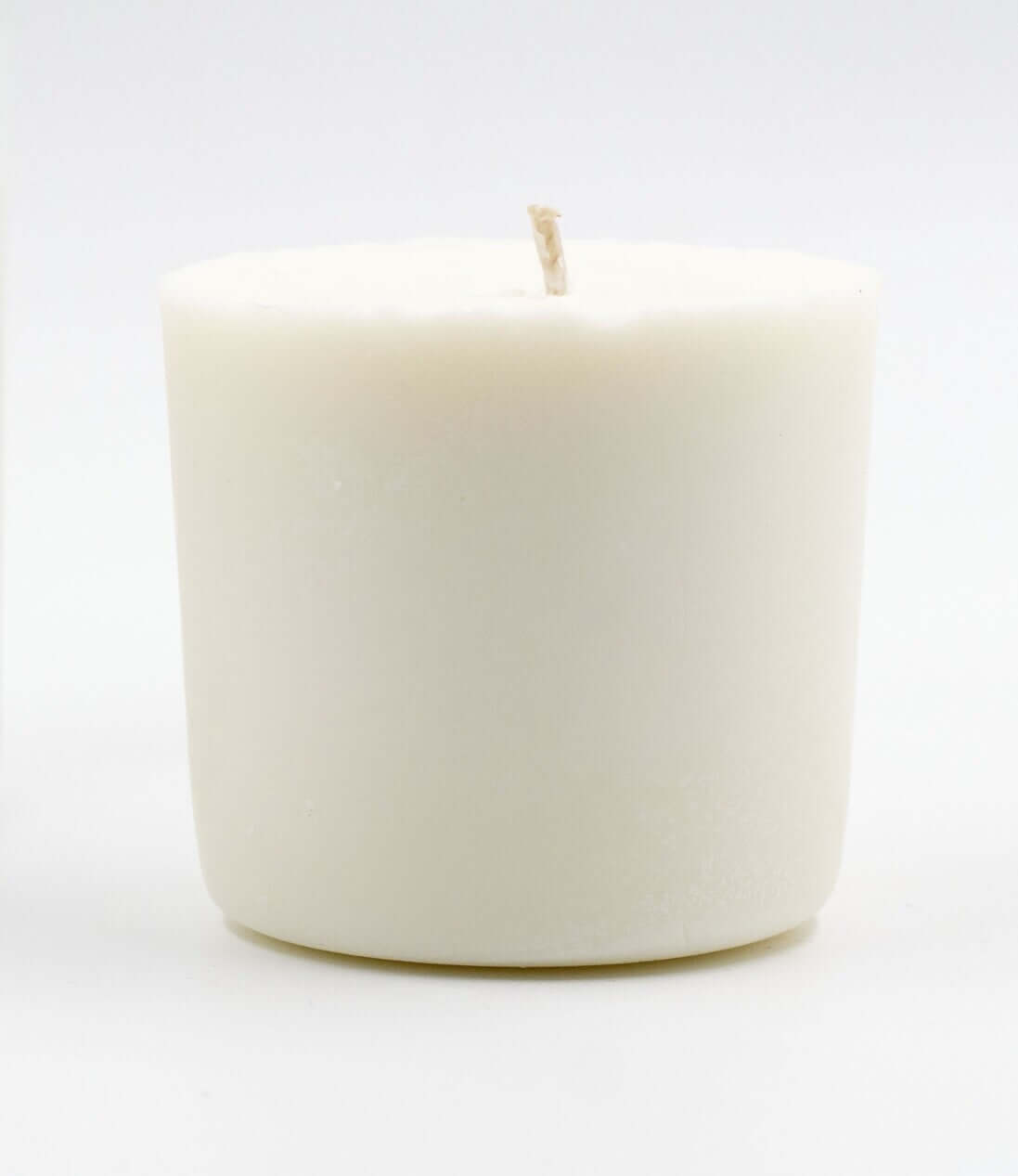 Close-up of a white candle refill, showcasing a simple, minimalist design without a container, ready to fit into an existing candle jar.