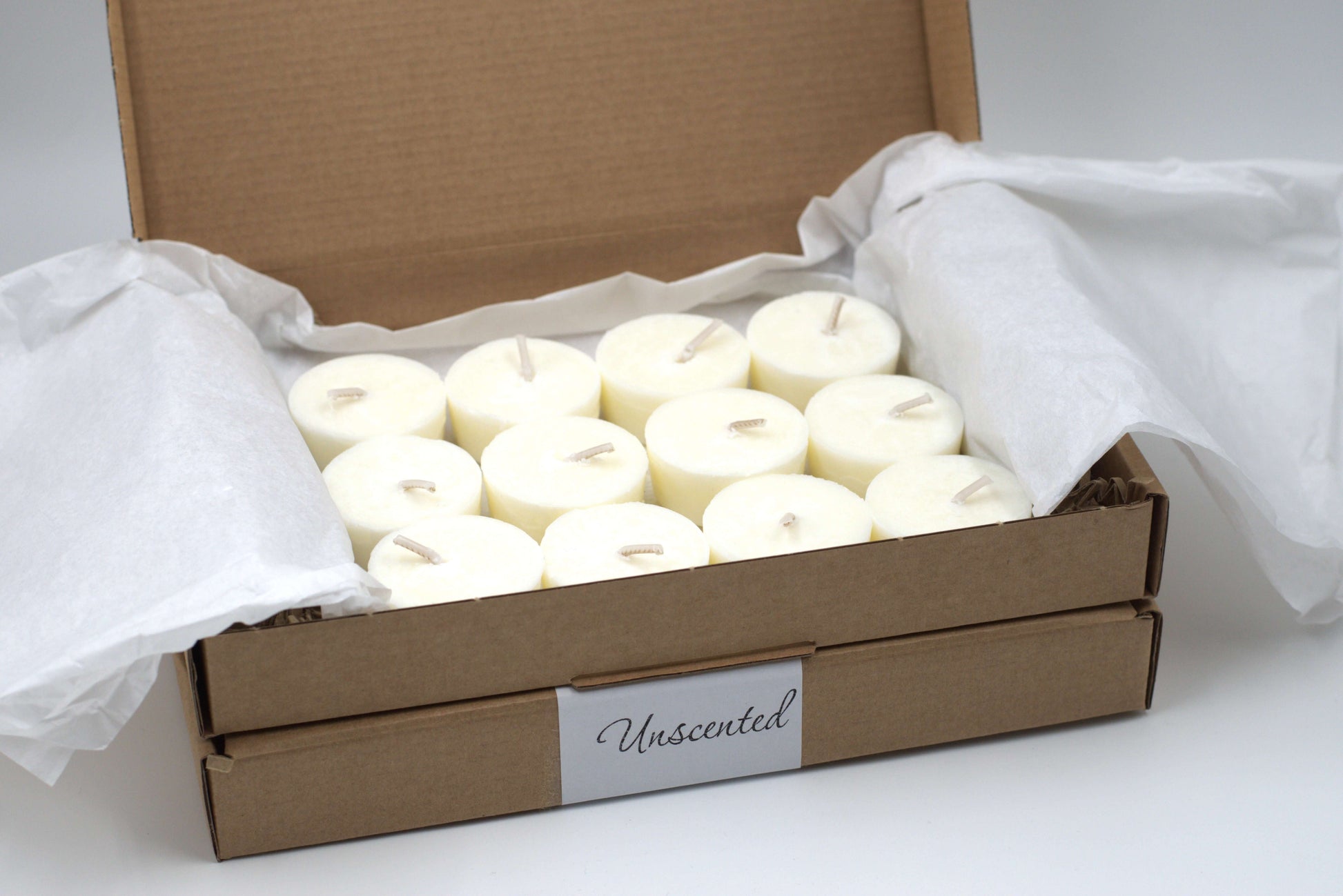 Twelve-pack of unscented tea light candles neatly packed in a cardboard box, perfect for use in refillable glass holders by Wonder Wick.