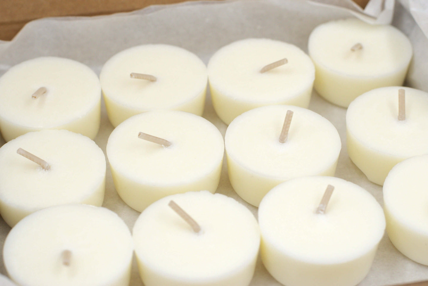 Close-up of 12 Clarity tealight refills by Wonder Wick, featuring smooth, creamy wax with natural cotton wicks. The high-quality hand-poured tealights are designed for a calming aromatherapy experience using lemon, cypress, and cedarwood essential oils.