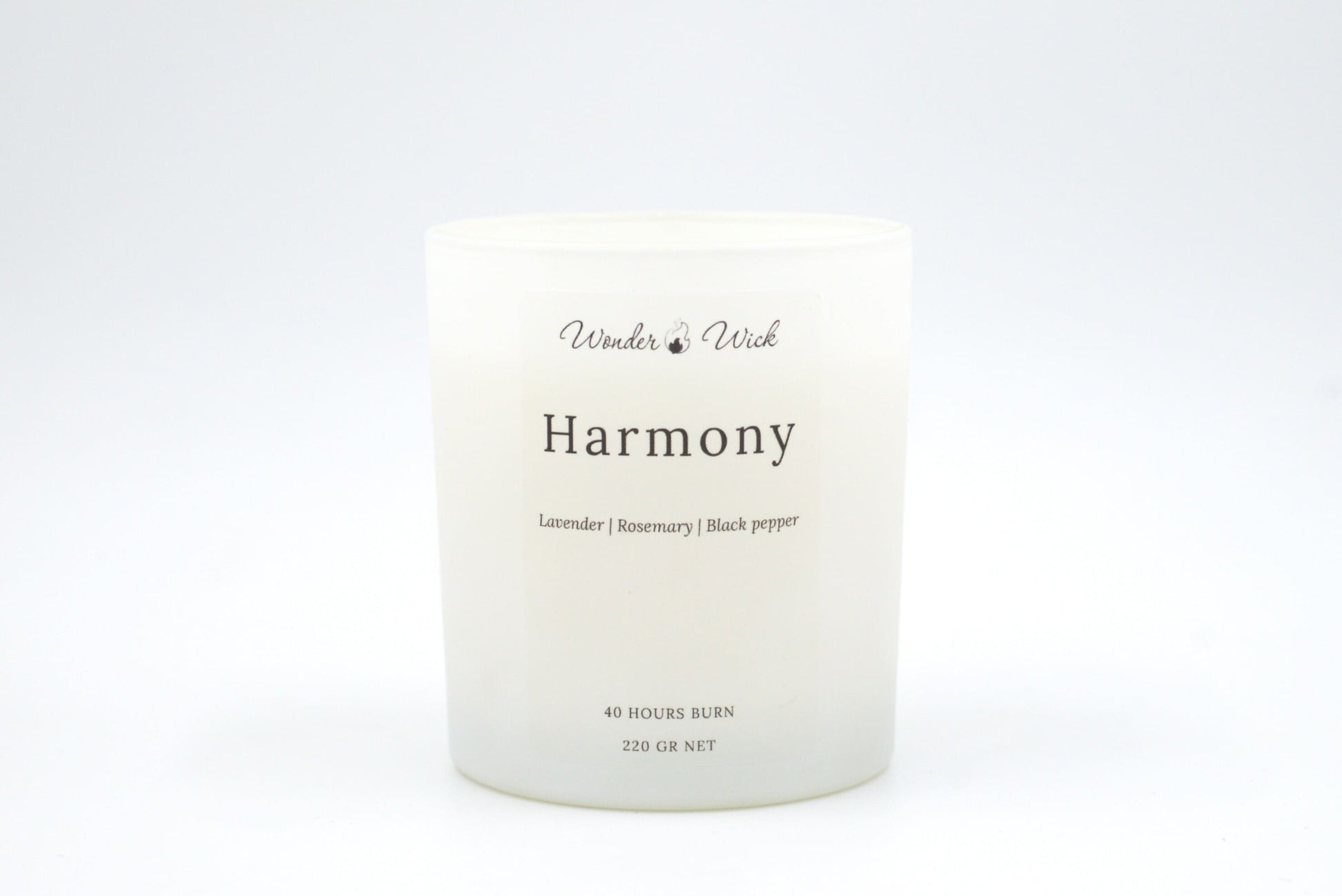 A close-up of the Harmony candle, showcasing its white matte glass jar with a natural, soothing scent of lavender, rosemary, and black pepper for a peaceful setting.