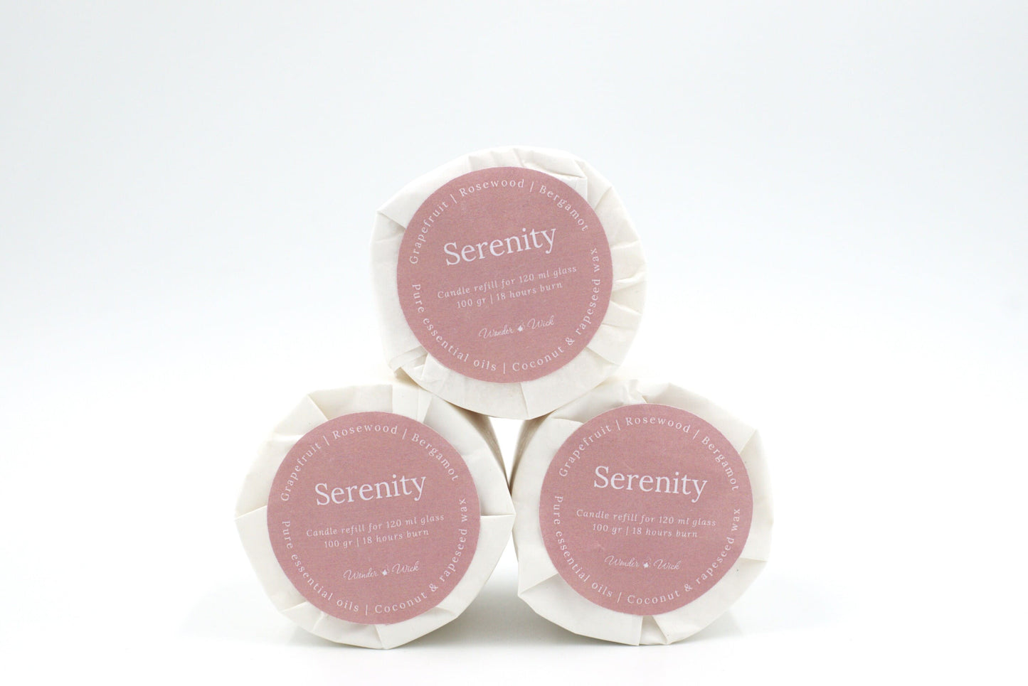 Three Serenity candle refills for 120 ml glass, stacked to display eco-conscious packaging with 18-hour burn time details, and ingredients like grapefruit, rosewood, and bergamot.