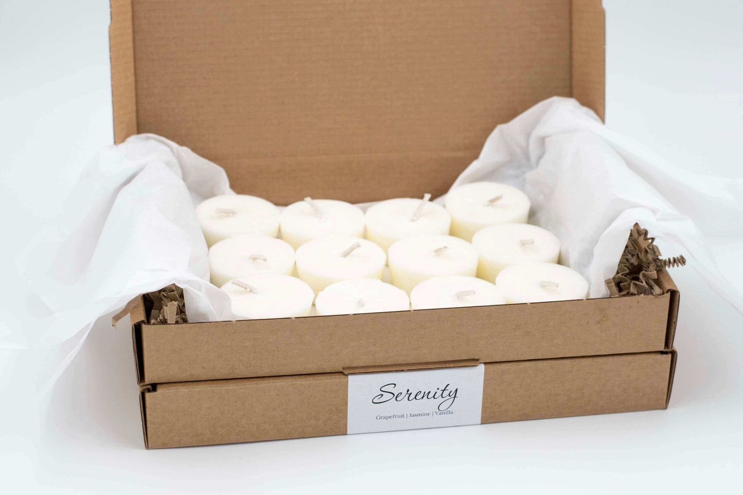 12-pack of Serenity scented tea light candles featuring grapefruit, vanilla, and jasmine, eco-friendly, vegan, and refillable, in a cardboard box